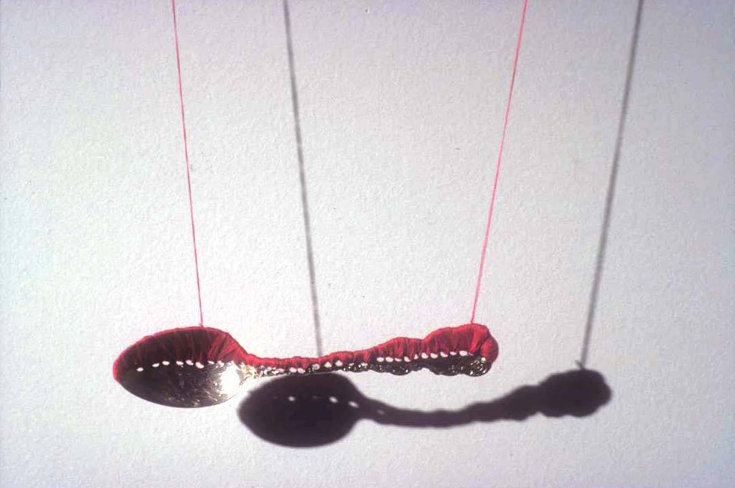Rae Goodwin, "constrain." sterling silver spoon, 300 yards cotton thread, needles and shadow.18”x 10”x 1” (2005) Rae Goodwin, "constrain." sterling silver spoon, 300 yards cotton thread, needles and shadow.18”x 10”x 1” (2005)